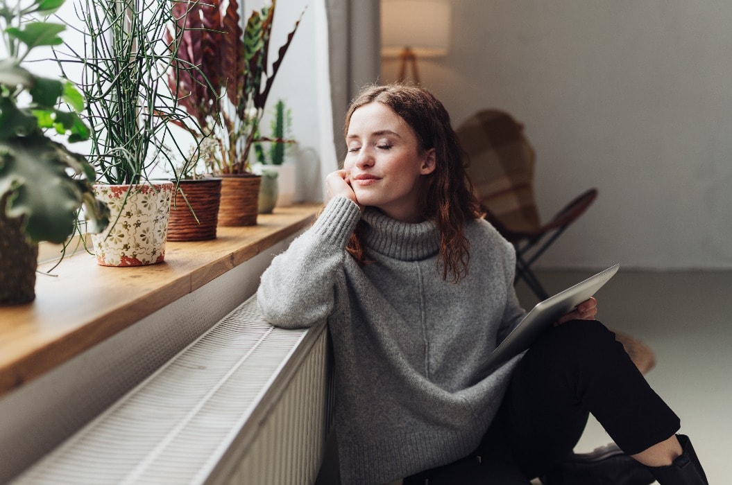 young woman relaxed at heater with tablet in hand