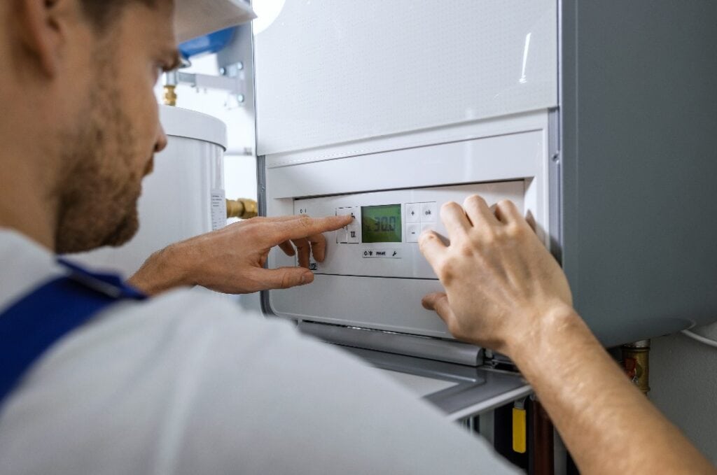 worker set up new central gas heating boiler for home