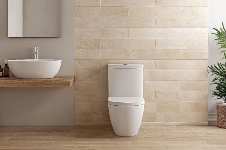 Ein modernes Badezimmer mit minimalistischem Design, einer weißen Toilette, einem stilvollen Waschbecken, Holzakzenten und einem Hauch von Grün.